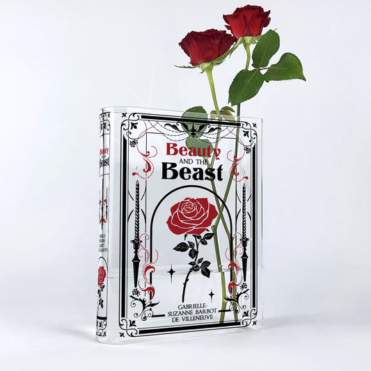 Beauty and the Beast acrylic book vase with two red roses against a white background